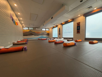 yogafusion Shanti Room with Blinds open and Bolster laid out with warm lighting